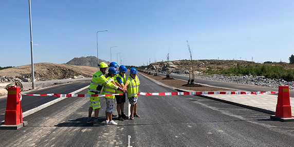 Fem personer i bygghjälmar klipper bandet vid en ceremoni för nya vägar i Logistik Bålsta